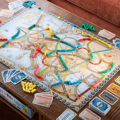 Ticket to Ride Europe board game setup showing the map of Europe covered in colorful plastic train pieces and cards.